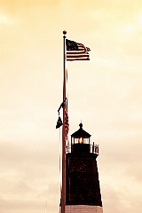 American Flag Waves Over Lighthouse